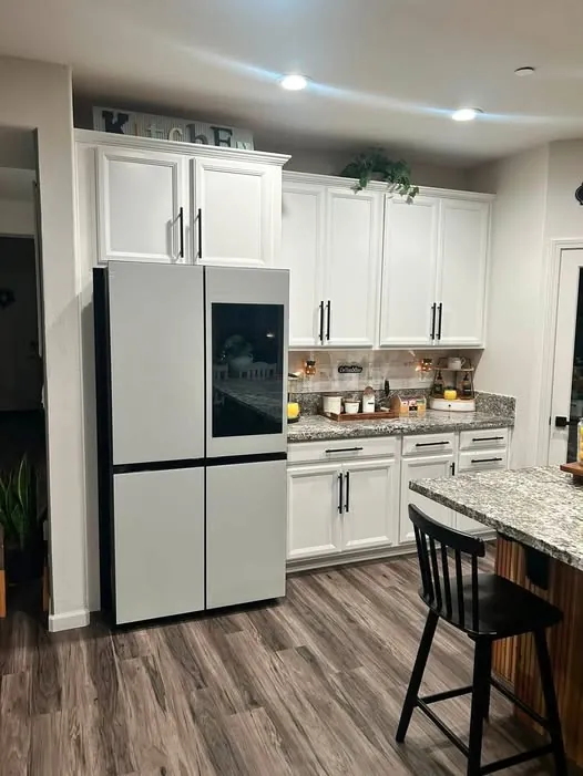 Spotless white kitchen with granite worktops and a polished floor